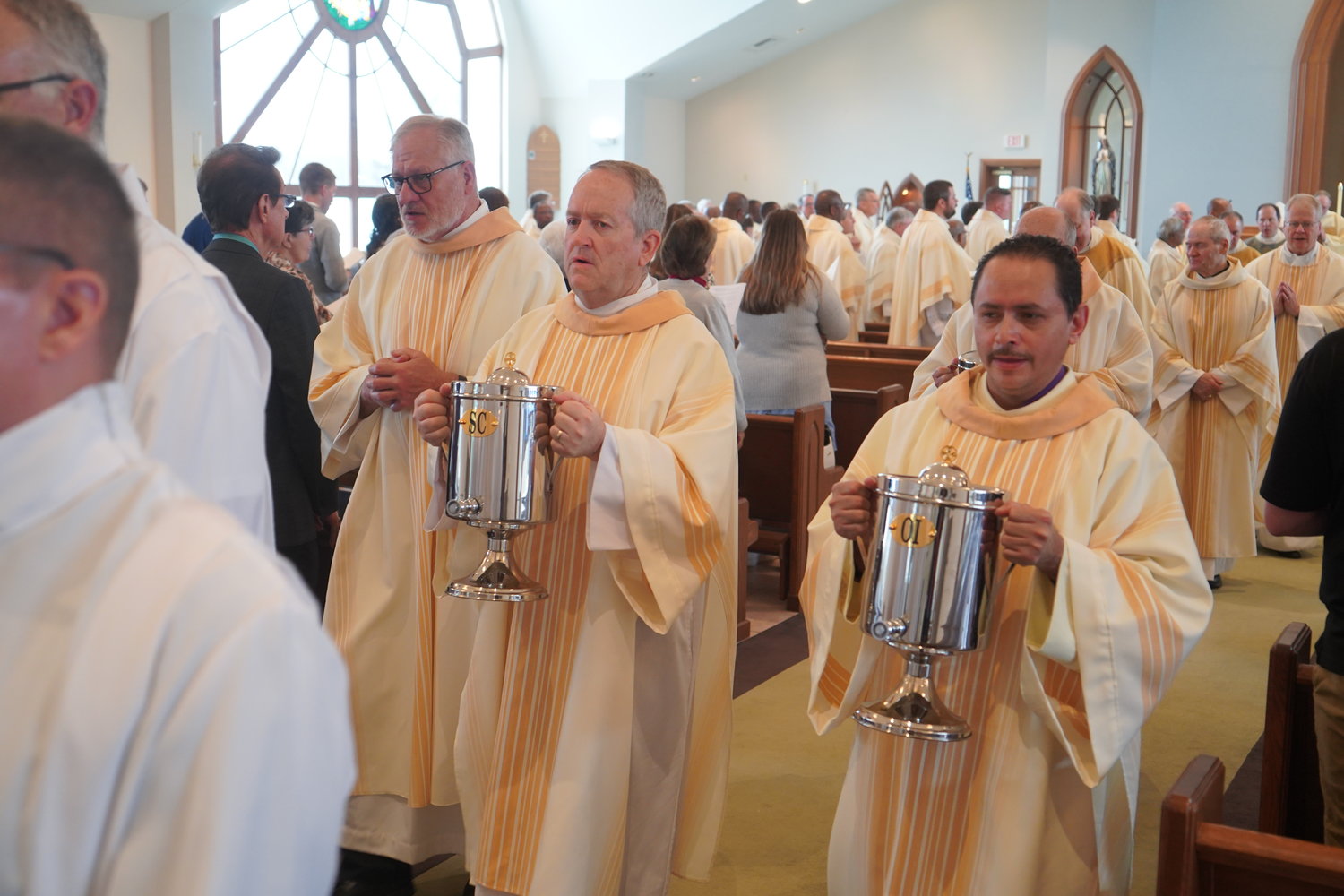 Deacon John Neudecker, Deacon Bruce Mobley and Deacon Edwin Pacheco process out of St. Andrew Church at the end of the Chrism Mass.